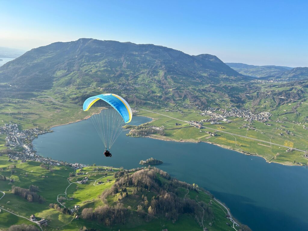 Passagierflug von der Schwand Richtung Seewen, im Hintergrund Rossberg mit Wildspitz, der Lauerzersee und die Doerfer LAuerz und Steinen